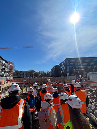 Kinder in Arbeitsschutzkleidung auf einer ZÜBLIN Baustelle.