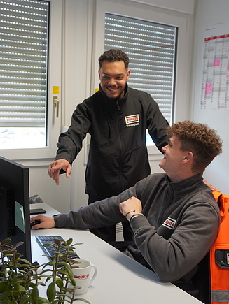 Joshua mit einem Kollegen am Arbeitsplatz