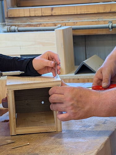 Children are making a birdhouse