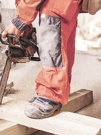 A piece of wood is being sawn using a chainsaw.
