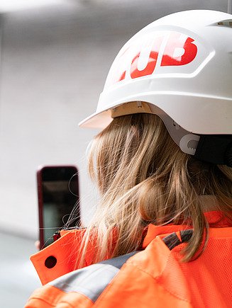 ZÜBLIN Mitarbeiterin mit Smartphone auf der Baustelle.
