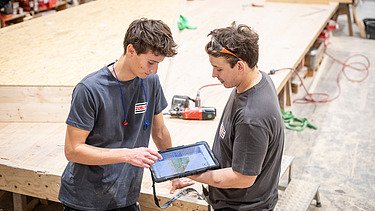 Zwei Auszubildende arbeiten gemeinsam mit Tablet