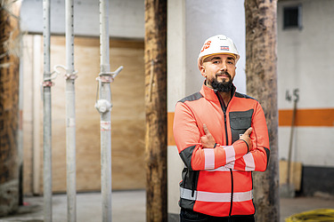 Workers in high-visibility clothing on a building site, with their arms crossed