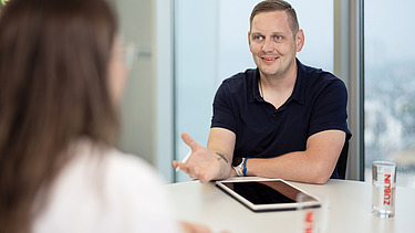 Recruiter bei ZÜBLIN Ein Recruiter und eine Bewerberin sitzen gemeinsam am Tisch und führen ein Vorstellungsgespräch.