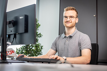An employee is sitting at a desk in the office