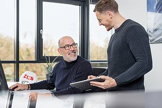 Foto von zwei ZÜBLIN-Mitarbeitern im Büro, die sich unterhalten.