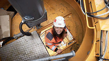Foto von einer Bauleiterin, die gerade auf den Bau-Kran klettert