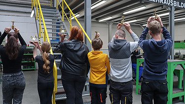 Kinder im Stahlwerk mit Kerzenständern