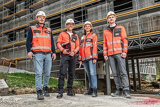 ZÜBLIN Mitarbeitende stehen in persönlicher Schutzausrüstung auf einem Baugerüst.