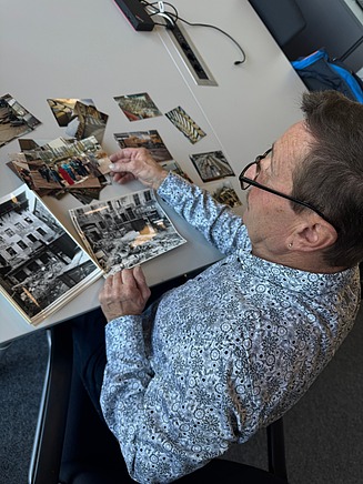 Mitarbeiter schaut sich alte Fotos an