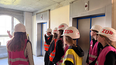 Children wearing high-visibility clothing on a building site
