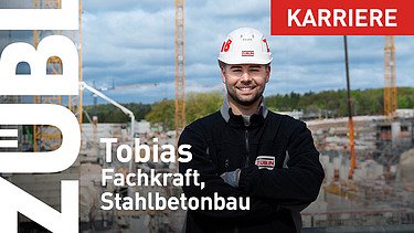 Junger Mann mit ZÜBLIN-Helm auf einer Großbaustelle