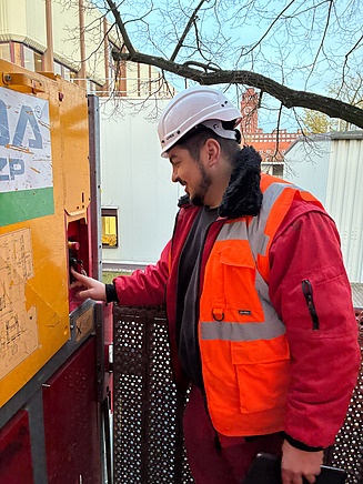 Mann in Arbeitsschutzkleidung an einem Sicherungskasten