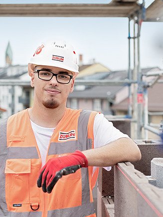 An apprentice wearing PPE on a building site.