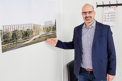 ZÜBLIN-Mitarbeiter, der im Büro steht und auf eine Visualisierung zeigt