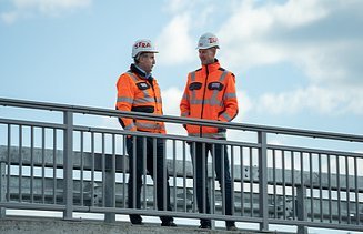 Zwei Männer in Arbeitsschutzkleidung auf der Baustelle