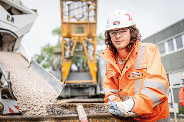 Junger Mann in Arbeitsschutzkleidung auf der Baustelle