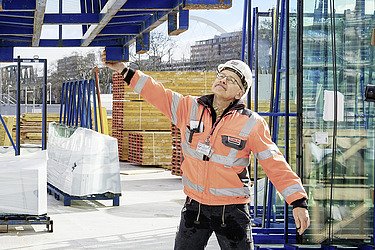 Foto von einem Mann in Sicherheitskleidung greift auf der Baustelle nach einer Metallkonstruktion