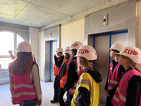 Children wearing high-visibility clothing on a building site