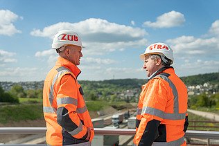 Zwei Männer in Arbeitsschutzkleidung auf der Baustelle