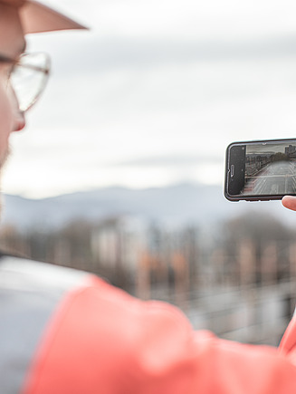ZÜBLIN Mitarbeiter mit PSA macht ein Foto mit dem Smartphone.