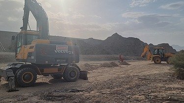 Zwei Baugeräte auf einer Baustelle im Oman