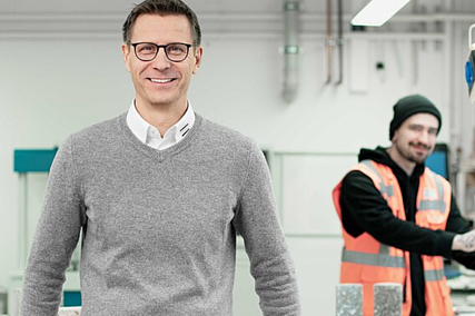 Foto von einem Mitarbeiter in einem Labor, der in die Kamera schaut