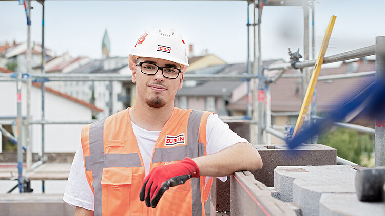 Junger Mann in Arbeitsschutzkleidung auf einer Baustelle