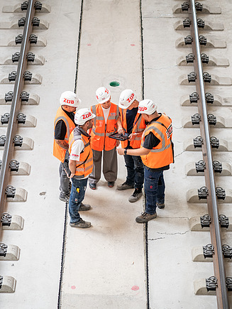 Foto von Kolleg:innen im Austausch auf einer Baustelle