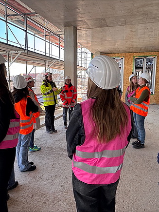 Kinder in Arbeitsschutzkleidung auf einer ZÜBLIN Baustelle.