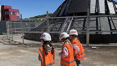 Children wearing high-visibility clothing on the S21 construction site