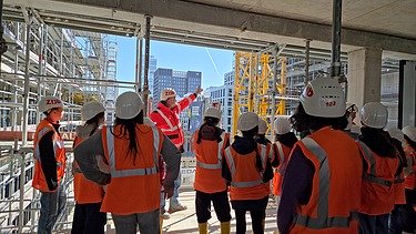Kinder in Arbeitsschutzkleidung auf einer Baustelle