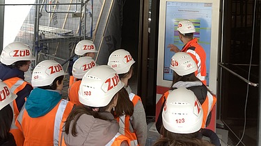Children wearing high-visibility clothing on a building site