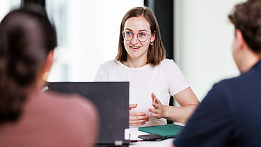 Three people in a meeting.