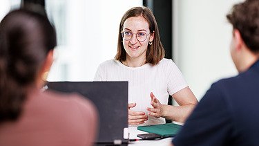 Three people in a meeting.