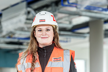 A young woman in an office smiles at the camera