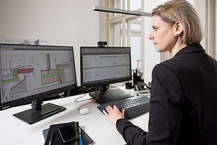 Foto von einer Projektleiterin, die gerade am PC arbeitet
