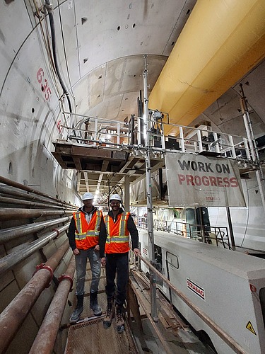 Two staff members wearing high-visibility clothing in the tunnel