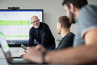 Foto von drei ZÜBLIN-Mitarbeiten in einer Besprechung im Büro.
