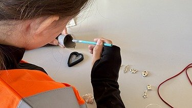 Nahaufnahme eines Mädchens, das Schmuck herstellt