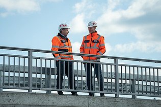 Zwei Männer in Arbeitsschutzkleidung auf der Baustelle