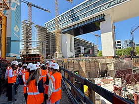 Children wearing high-visibility clothing on a building site