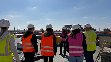 Children wearing high-visibility clothing on a building site