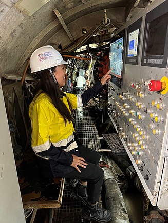 Junge Frau in Arbeitsschutzkleidung in der Steuerzentrale