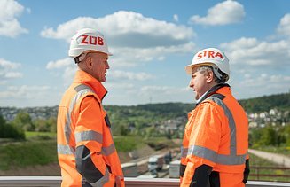 Zwei Männer in Arbeitsschutzkleidung auf der Baustelle