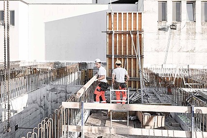 Foto von zwei Männern, die auf einer Baustelle arbeiten 