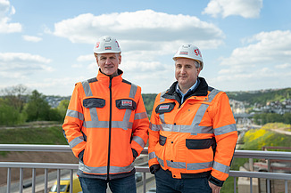 Zwei Männer in Arbeitsschutzkleidung auf einer Baustelle
