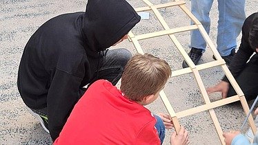 Zwei Schüler bauen an der Leonardo-Brücke.