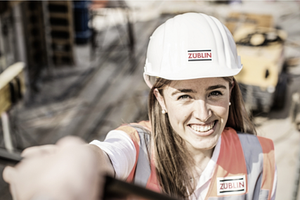 Foto von ZÜBLIN Mitarbeiterin mit Baustelle im Hintergrund