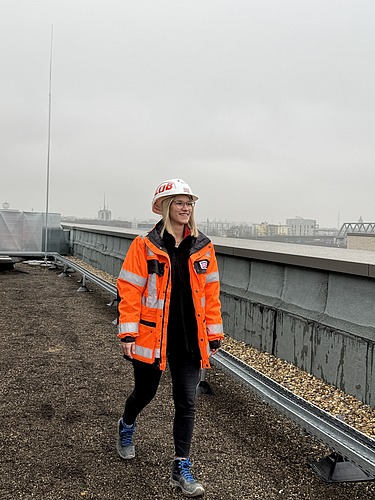 Junge ZÜBLIN Mitarbeiterin mit PSA auf einer Baustelle.